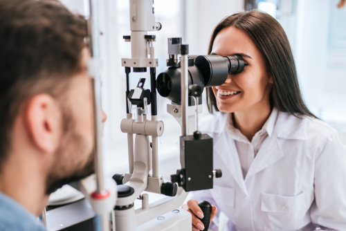 Picture of a female Optometrist doing an eye exam on a male patient.