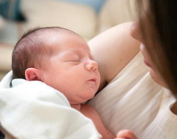 photo of woman holding baby